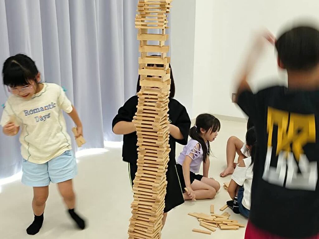北日野自治振興会 高く積み上げたカプラ作品と子どもたち