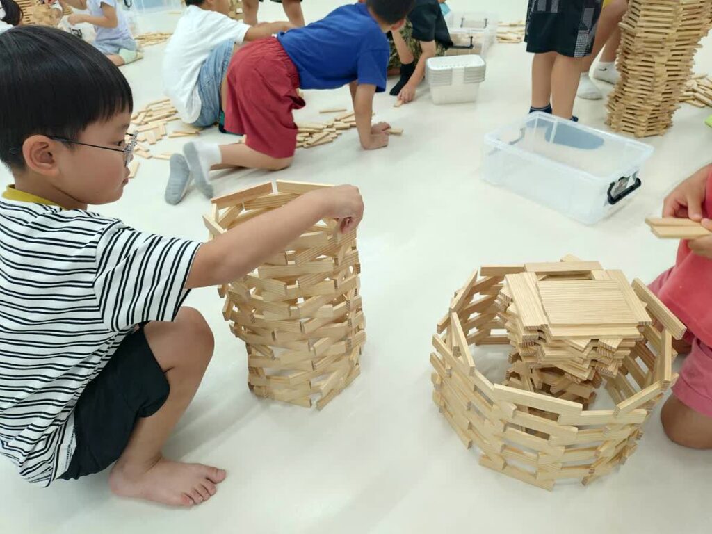 北日野自治振興会 カプラで円筒形の作品を作る子ども