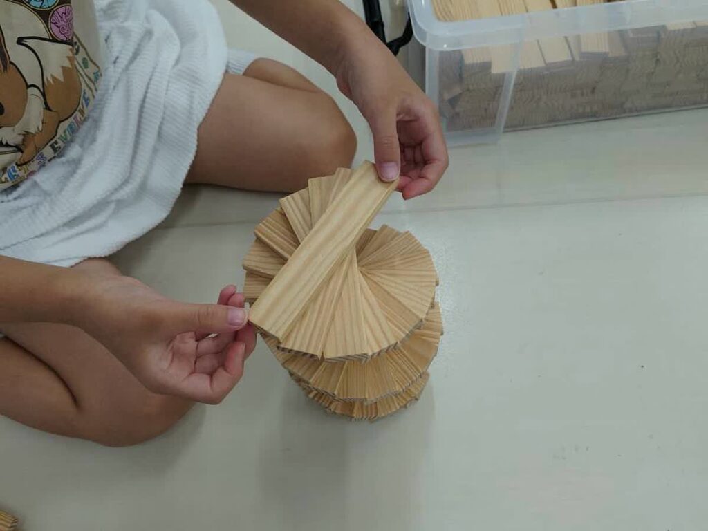 北日野自治振興会 カプラでらせん状の作品を作る子ども