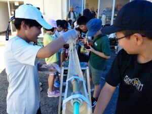 北日野自治振興会 竹台を流れるそうめんをすくう子どもたち