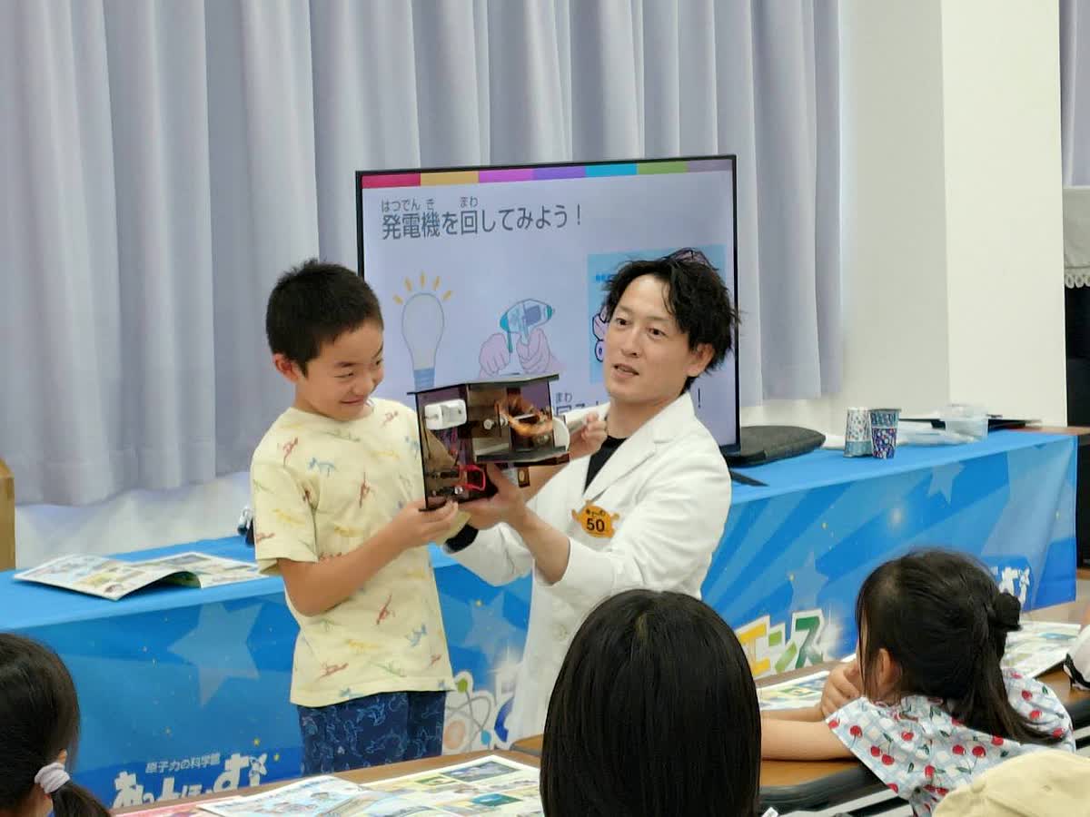 北日野自治振興会 発電機を回して発電の仕組みを体験する様子