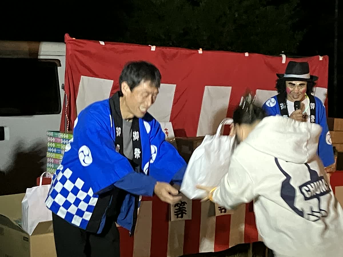 北日野自治振興会 帆山町秋祭りの福引きで賞品を受け取る参加者