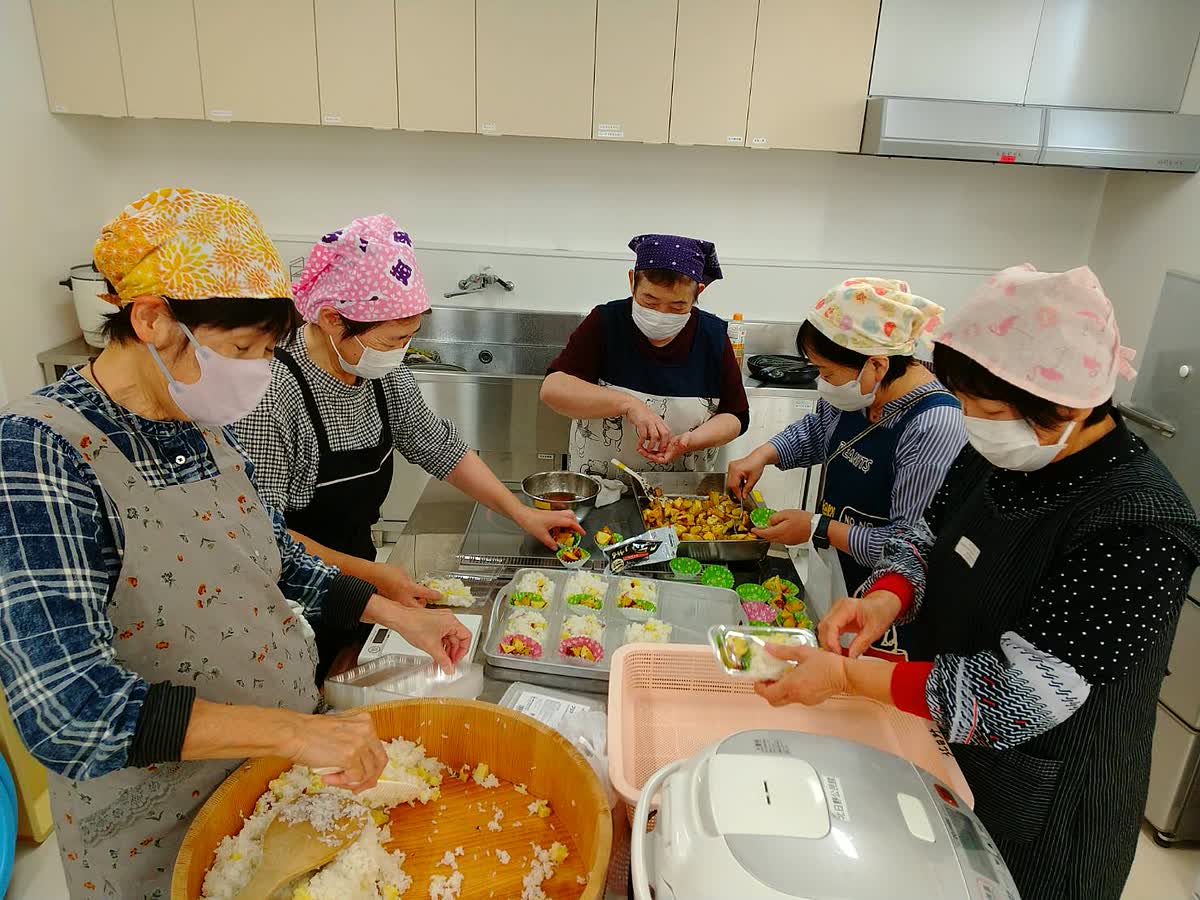 北日野自治振興会 さつまいもご飯と大学いもを盛り付ける赤十字奉仕団の皆さん