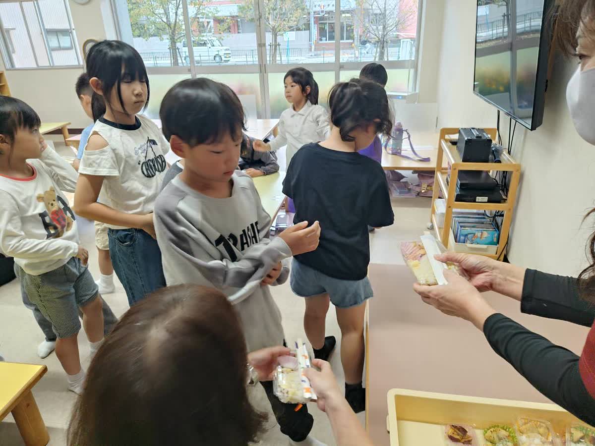 北日野自治振興会 さつまいもご飯を受け取る子どもたち